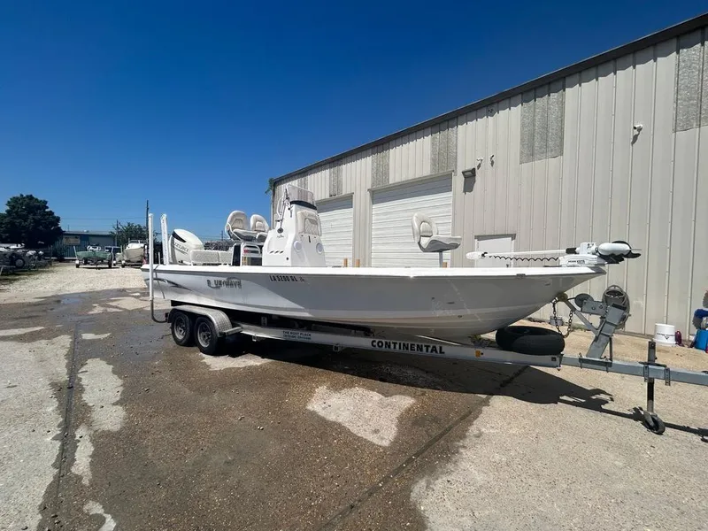 Slide: The Image of 2019 Blue Wave 2400 PureBay boat on a Continental trailer outside a warehouse. - 7