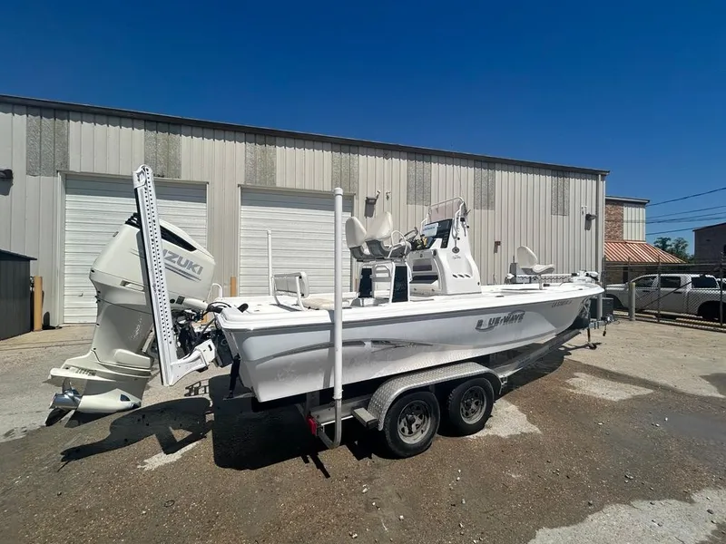 Slide: The Image of 2019 Blue Wave 2400 PureBay boat on a trailer outside a warehouse. - 9