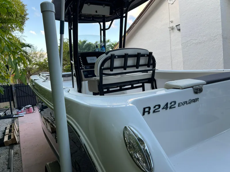Slide: The Image of 2018 Robalo R242 Center Console boat docked near a house. - 16
