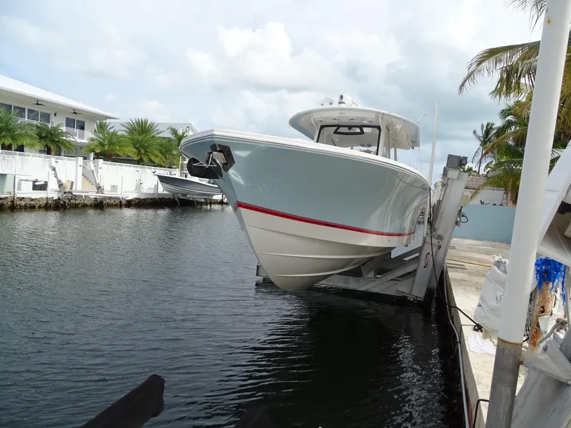 Slide: The Image of 2022 Regulator 41 boat docked by waterfront homes and palm trees. - 10