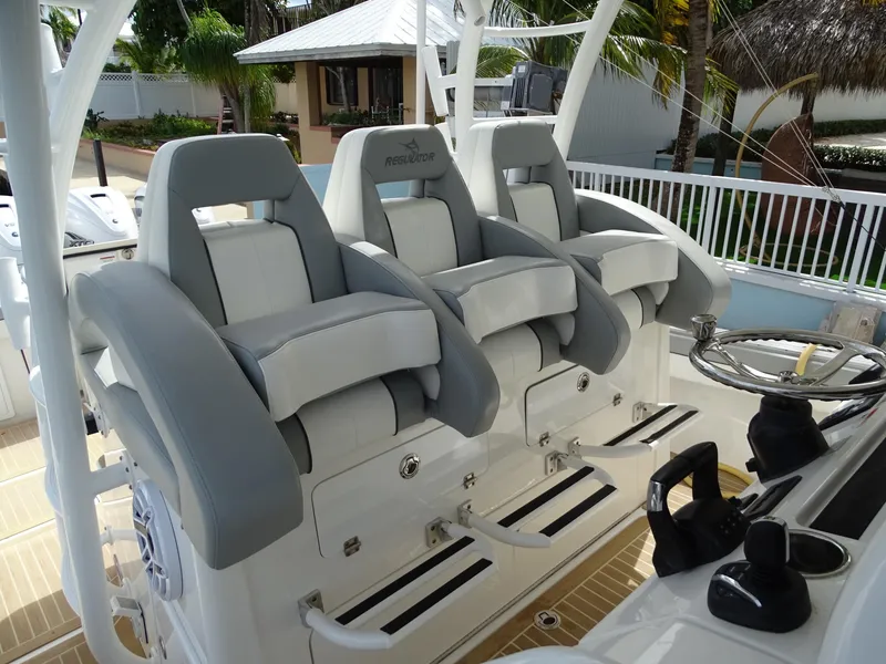 Slide: The Image of 2022 Regulator 41 boat with three cushioned helm seats and steering wheel. - 19