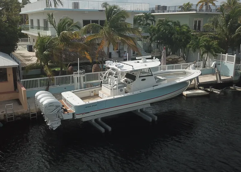 Slide: The Image of 2022 Regulator 41 boat docked near waterfront homes with palm trees. - 3
