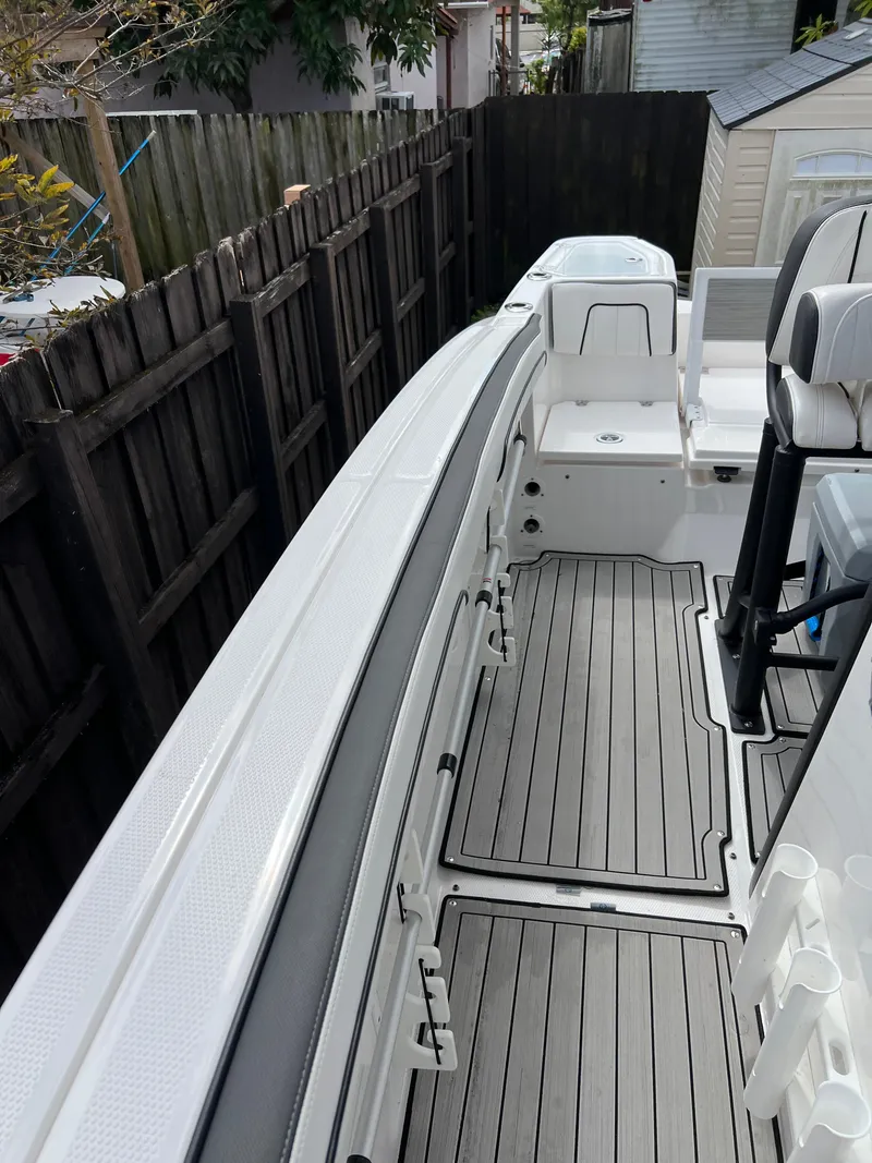 Slide: The Image of 2021 Yamaha Boats FSH 255 Sport E deck view with seating and storage compartments. - 17