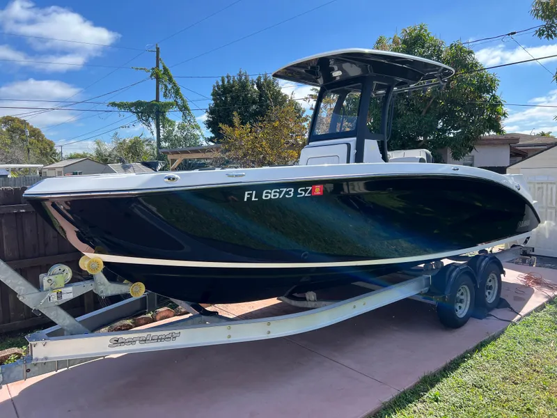 Slide: The Image of 2021 Yamaha Boats FSH 255 Sport E on trailer in driveway. - 2