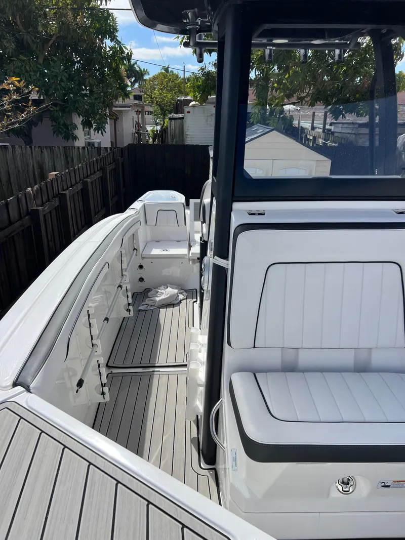 Slide: The Image of 2021 Yamaha Boats FSH 255 Sport E, sleek white interior, docked in a residential area. - 28