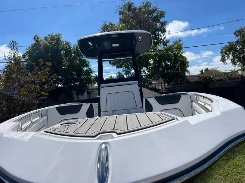 Slide: The Image of 2021 Yamaha Boats FSH 255 Sport E, front deck view under clear blue sky. - 3