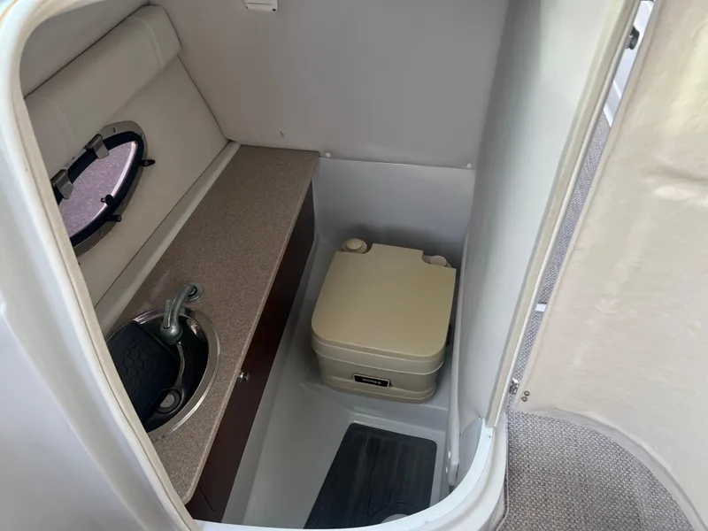 Slide: The Image of 2016 Crownline 270 SS boat interior bathroom with sink and portable toilet. - 42