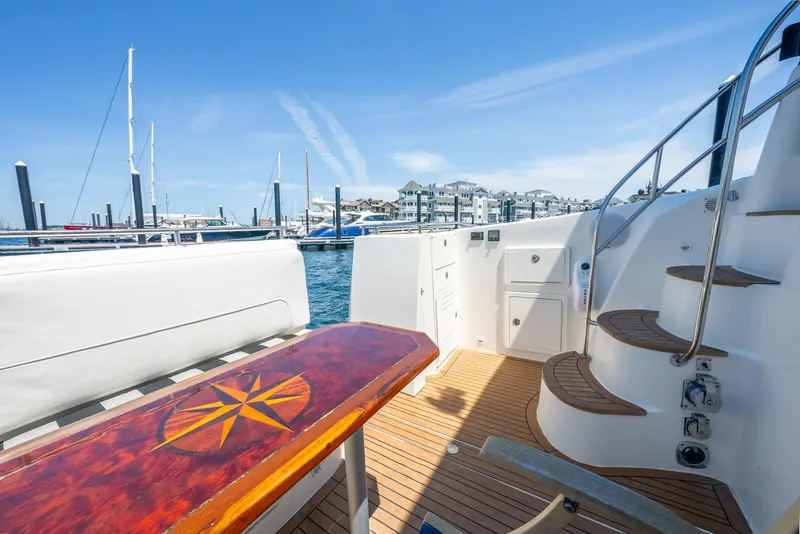 Slide: The Image of 2004 Meridian 459 Motor Yacht deck with wooden table and marina view. - 12