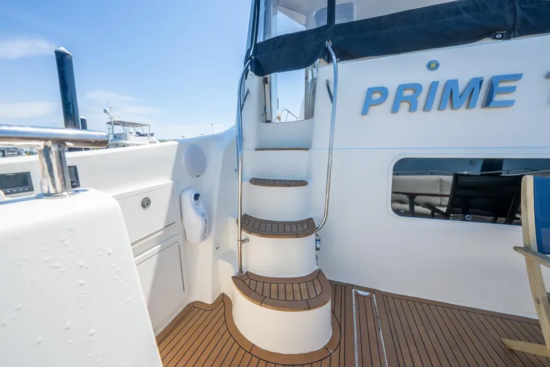 Slide: The Image of 2004 Meridian 459 Motor Yacht, teak deck, spiral staircase, marina background. - 16