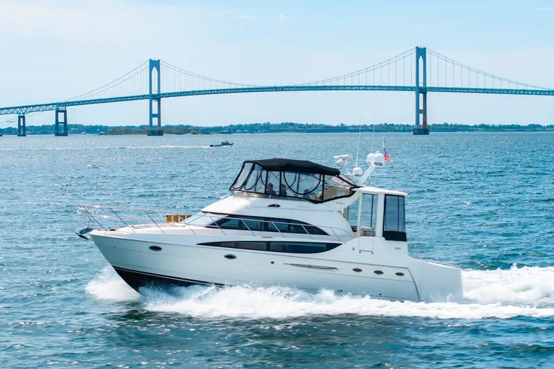 Slide: The Image of 2004 Meridian 459 Motor Yacht cruising near a large suspension bridge on a sunny day. - 8