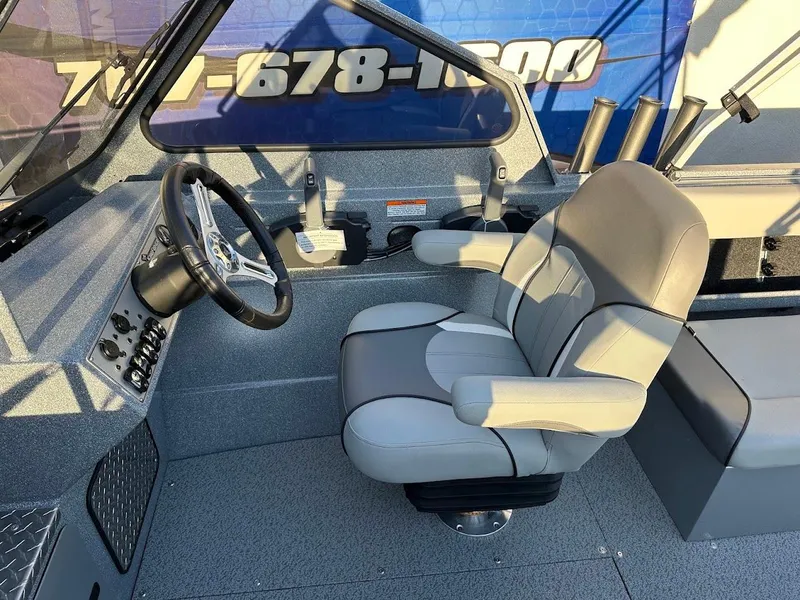 Slide: The Image of Interior of 2024 KingFisher 2025 Falcon boat with gray captain's chair and steering wheel. - 16