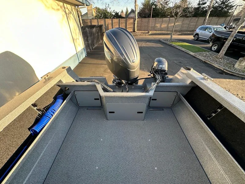 Slide: The Image of KingFisher 2025 Falcon boat, 2024 model, with powerful outboard motor, parked outdoors. - 23