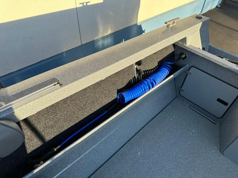 Slide: The Image of Interior view of a 2024 KingFisher 2025 Falcon boat, featuring storage compartment and coiled blue hose. - 24