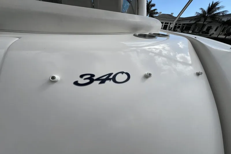 Slide: The Image of 2005 Sea Ray 340 Sundancer boat with sleek white exterior and model emblem. - 13