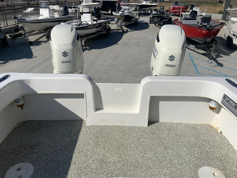Slide: The Image of 2018 Twin Vee 310 GF boat with dual Suzuki 300 outboard engines in a marina. - 7