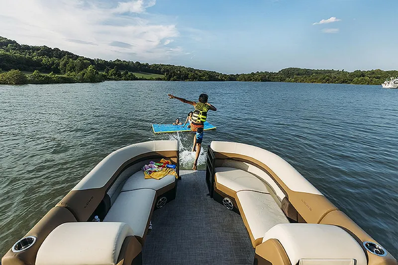 Slide: The Image of 2024 Lowe SS210 pontoon boat on a lake with kids jumping into the water. - 12