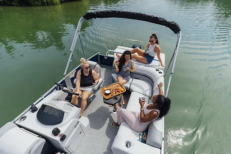 Slide: The Image of 2024 Lowe SS210 pontoon boat with friends enjoying drinks and snacks on the water. - 13