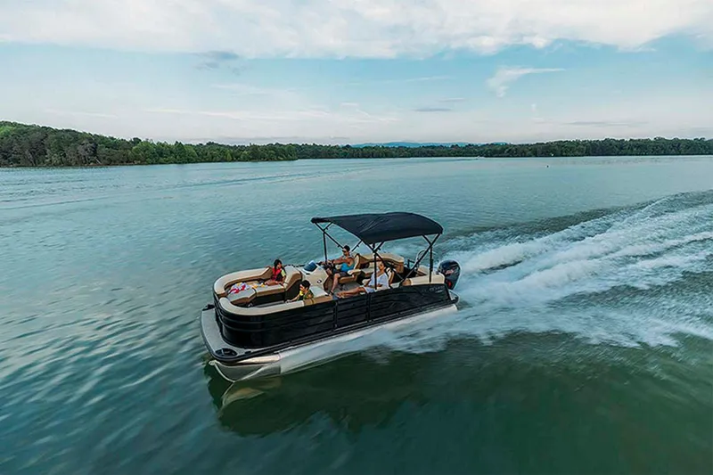Slide: The Image of 2024 Lowe SS210 pontoon boat cruising on a serene lake. - 16