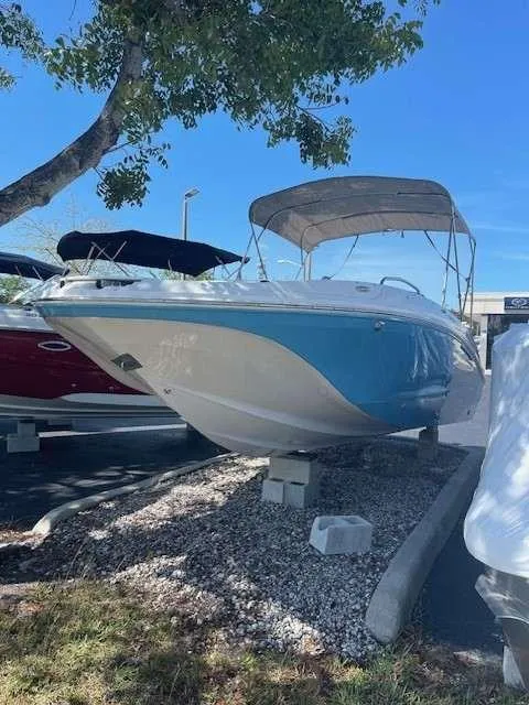 Slide: The Image of 2024 Hurricane 218 SS boat on display under a tree. - 1