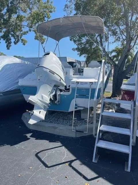 Slide: The Image of 2024 Hurricane 218 SS boat with outboard motor and canopy, parked on a trailer. - 10
