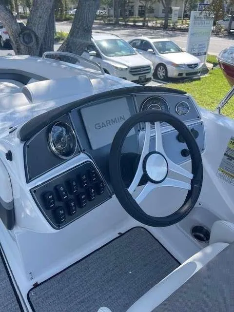 Slide: The Image of 2024 Hurricane 218 SS boat dashboard with Garmin navigation system and steering wheel. - 6