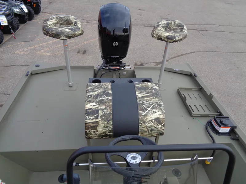 Slide: The Image of 2024 Tracker Grizzly 2072 CC Sportsman boat with camo seats and outboard motor. - 12