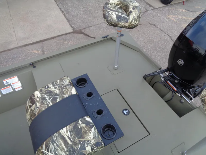 Slide: The Image of 2024 Tracker Grizzly 2072 CC Sportsman boat with camo seats and outboard motor. - 13
