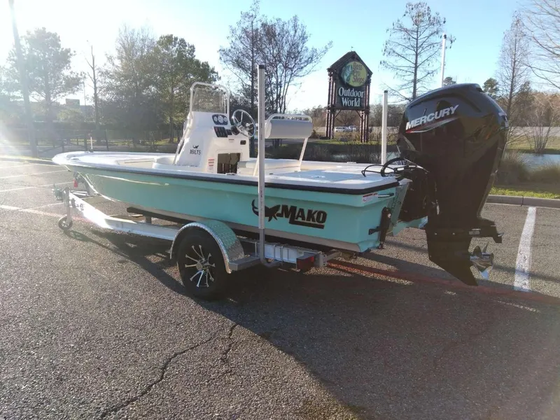 Slide: The Image of 2024 Mako 18 LTS boat with Mercury engine on a trailer in a parking lot. - 2