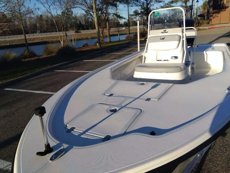 Slide: The Image of 2024 Mako 18 LTS boat in a parking lot near a lake. - 8