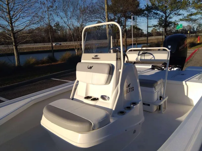 Slide: The Image of 2024 Mako 18 LTS boat with seating and console, parked near a lake. - 9