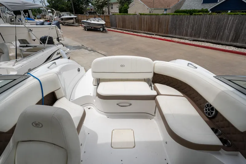 Slide: The Image of 2011 Cobalt 242 boat interior with white and beige seating, docked at a marina. - 11