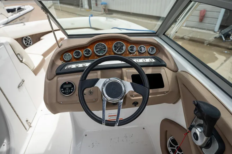 Slide: The Image of 2011 Cobalt 242 boat dashboard with steering wheel and control panel. - 15