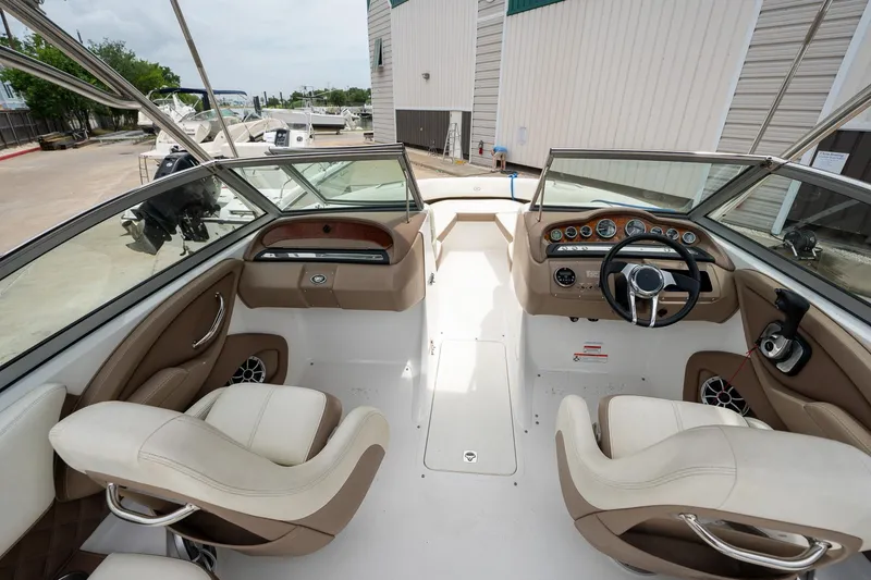 Slide: The Image of 2011 Cobalt 242 boat interior with dual captain's chairs and dashboard. - 16