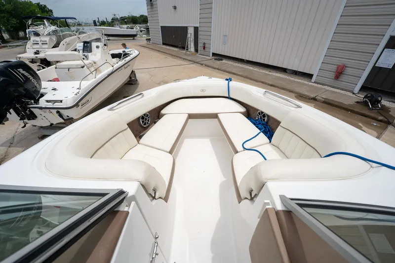 Slide: The Image of 2011 Cobalt 242 boat with spacious white seating area docked at marina. - 17
