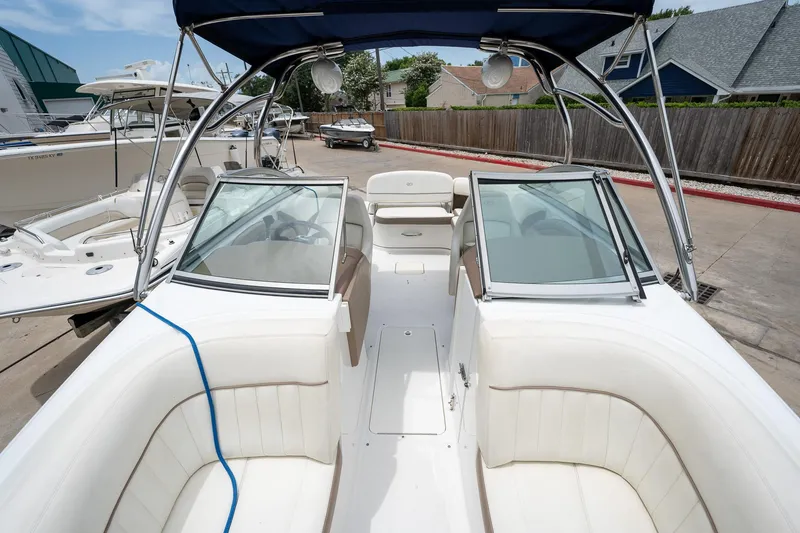 Slide: The Image of 2011 Cobalt 242 boat with white interior and blue canopy. - 18