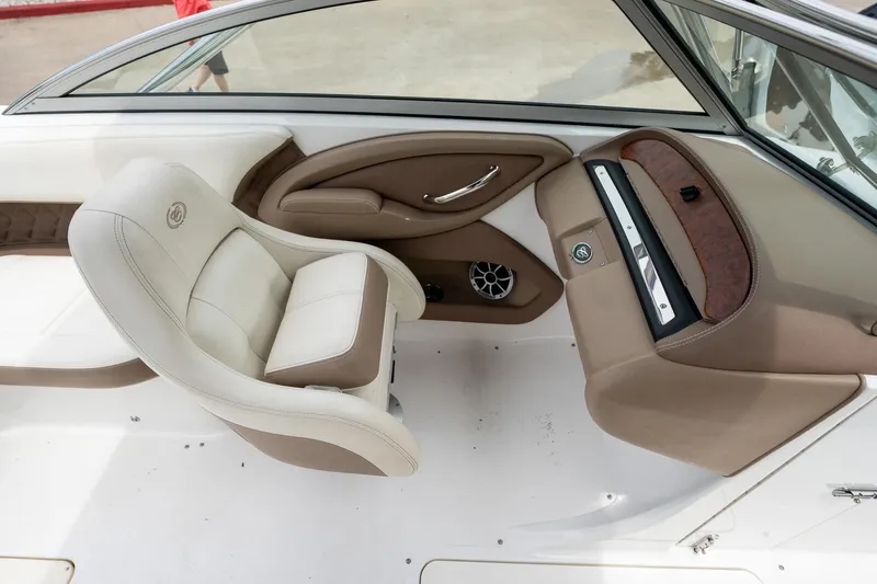 Slide: The Image of Interior of a 2011 Cobalt 242 boat featuring a beige and brown captain's chair. - 24