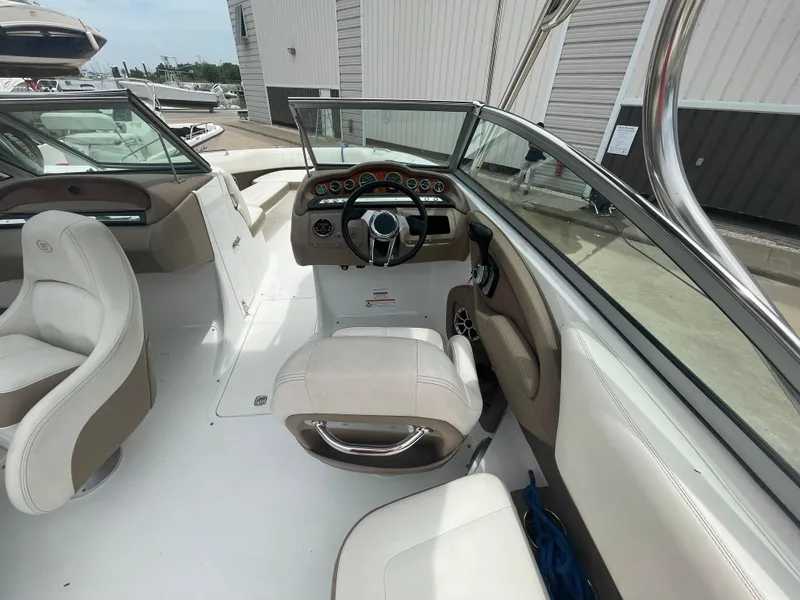Slide: The Image of 2011 Cobalt 242 boat interior with steering wheel and seating. - 31