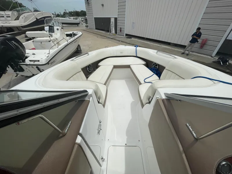 Slide: The Image of 2011 Cobalt 242 boat with white and beige interior, docked at a marina. - 32