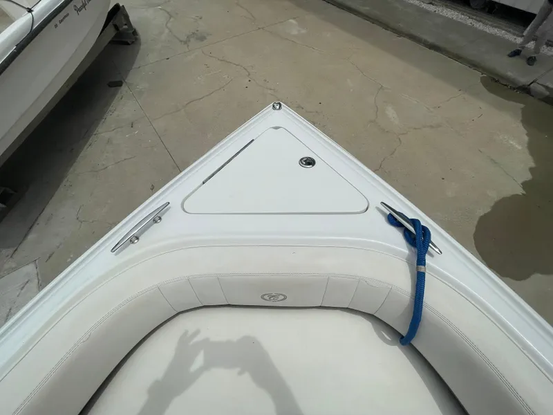 Slide: The Image of 2011 Cobalt 242 boat bow with white seating and blue rope. - 33