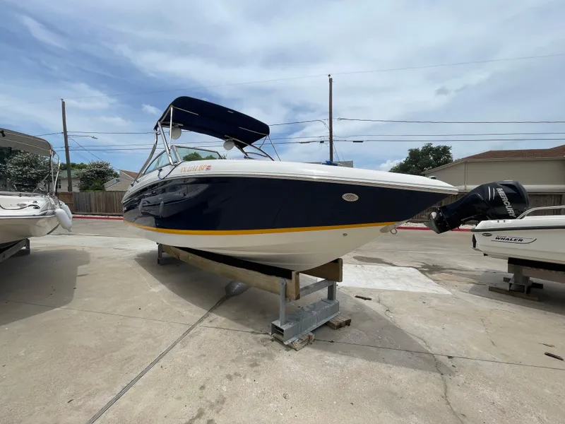 Slide: The Image of 2011 Cobalt 242 boat on a stand, blue hull, outdoor display. - 43