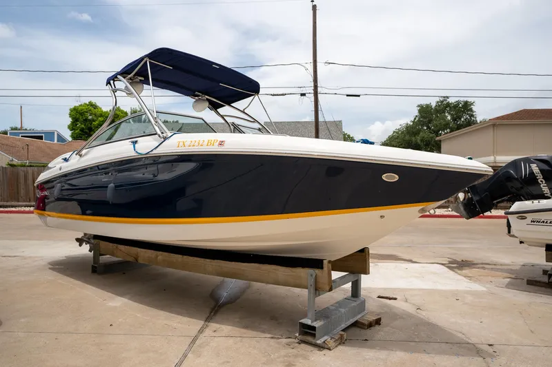 Slide: The Image of 2011 Cobalt 242 boat on a trailer, blue and white with a canopy. - 5