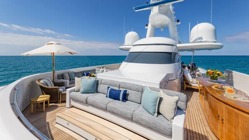 Slide: The Image of Luxurious 2003 Feadship 51.8M yacht deck with seating, ocean view, and bar. - 24