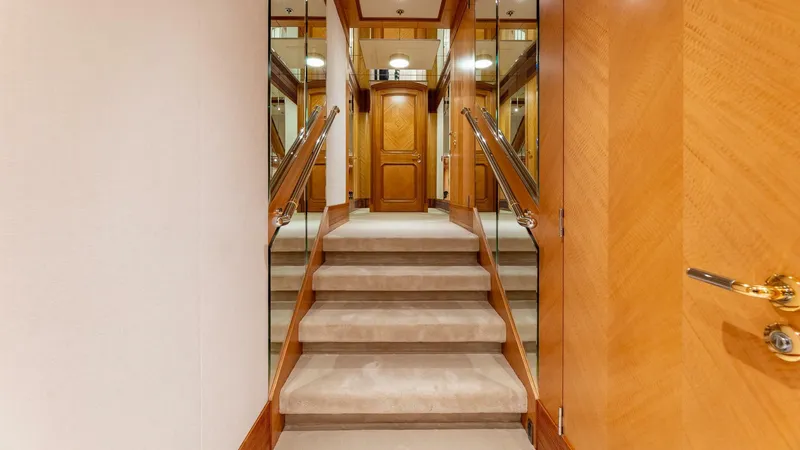 Slide: The Image of Luxurious interior staircase of 2003 Feadship 51.8M yacht with wooden accents and mirrored walls. - 43
