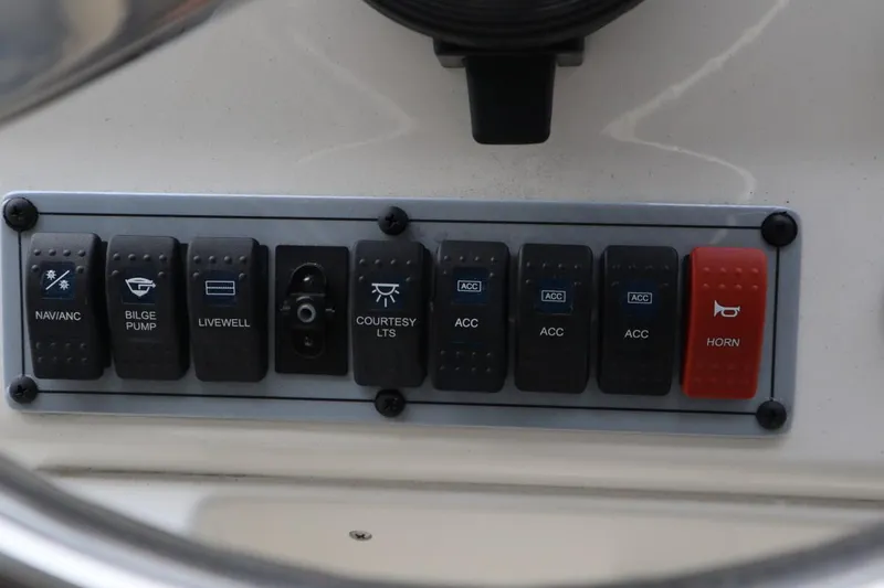 Slide: The Image of Control panel of a 2024 Key West 179FS boat with various switches. - 12