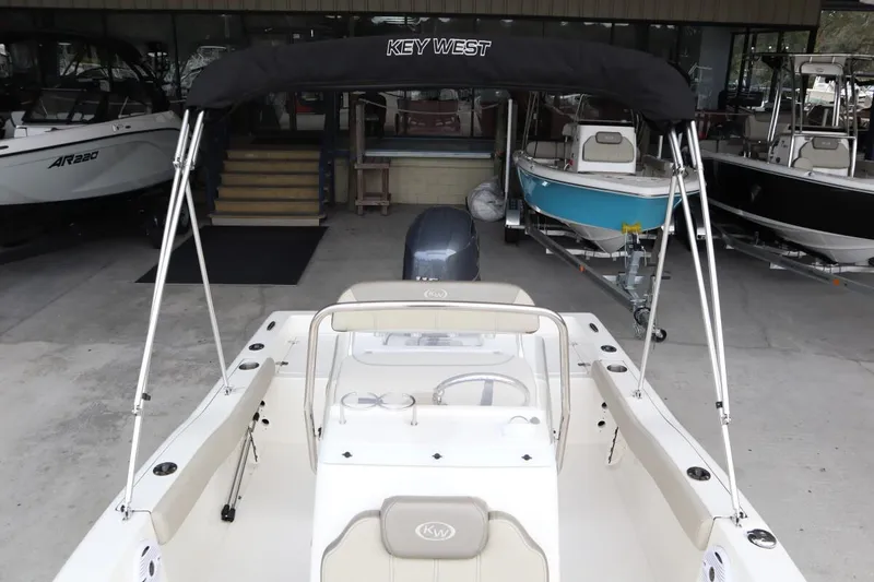 Slide: The Image of 2024 Key West 179FS boat interior with canopy, docked in a showroom. - 8
