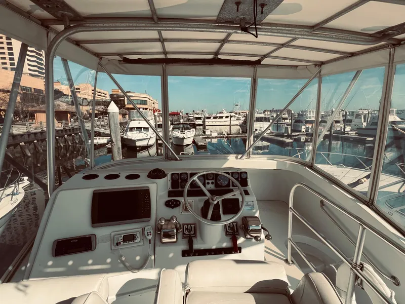 Slide: The Image of Cockpit view of a 1999 Luhrs 360 Sportfish yacht docked at a marina. - 13
