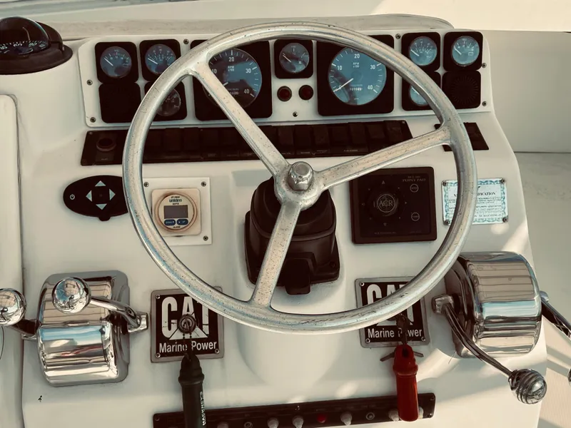 Slide: The Image of 1999 Luhrs 360 Sportfish boat helm with steering wheel and control panel. - 14
