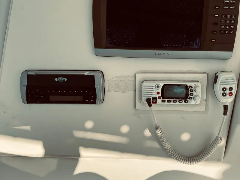 Slide: The Image of 1999 Luhrs 360 Sportfish electronics panel with Garmin display, radio, and communication equipment. - 18