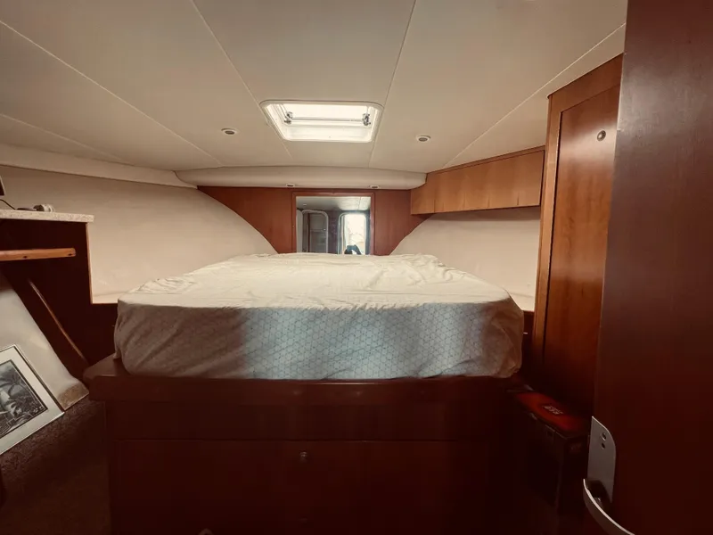 Slide: The Image of 1999 Luhrs 360 Sportfish cabin interior with bed and wooden cabinetry. - 25