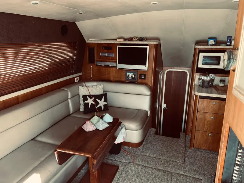 Slide: The Image of 1999 Luhrs 360 Sportfish interior with seating, table, and entertainment system. - 31